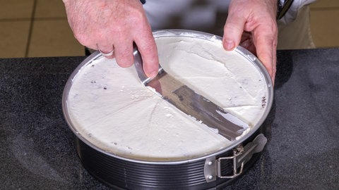 Sahne wird auf den Boden der Eierlikörtorte gestrichen.