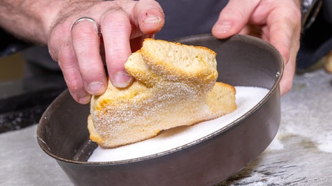 Nach dem Backen werden die Quarkhasen zu Ostern ganz einfach mit geschmolzener Butter bestrichen und mit Zucker bestreut.