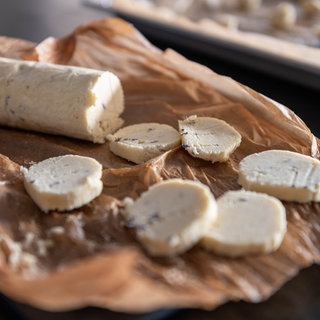 Rolle mit gefrorenem Keksteig und ein paar aufgeschnittene Scheiben davon