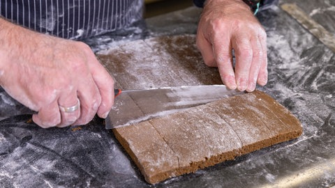 Printenteig wird in rechteckige Stücke geschnitten.