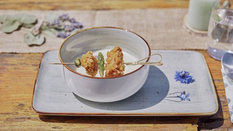 Spargelcremesuppe mit Spieß vom Weidehähnchen in einer Schale