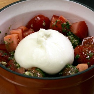 Grillgemüse mit Burrata - brutzelt im gusseisernen Topf auf dem Grill.