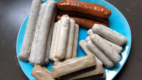 Verschiedene vegane und vegetarische Bratwürste auf einem Teller