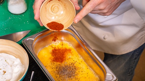 Panade für das Schnitzel aus Blumenkohl:Das Ei wird mit Salz, Pfeffer und Paprikapulver vermischt.