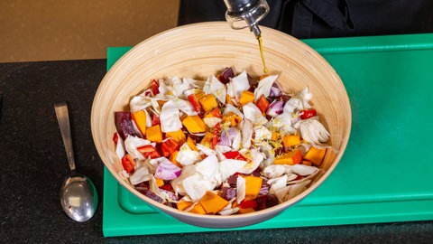 Die Zutaten für das Kürbisgemüse müssen mit Olivenöl gut gemischt werden.