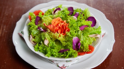 Salat mit Rosenblüten auf einem Teller
