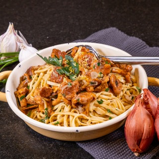 Pfifferlinge mit Nudeln: Cremige Pasta in einem Topf mit Pilzen. Wie im Rezept beschrieben: einfach und schnell zubereitet.