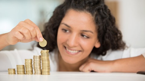 Junge Frau stapelt Geldmünzen