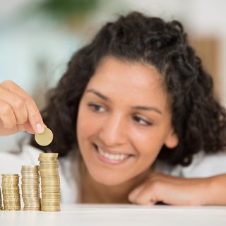 Junge Frau stapelt Geldmünzen