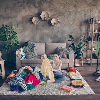 Frau Sortiert Kleidung aus