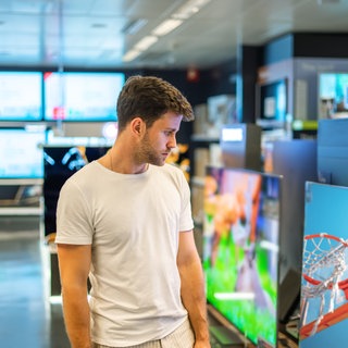 Junger Mann beim Fernsehkauf