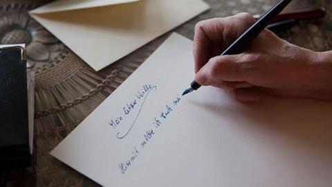 Eine ältere Frau schreibt ihr Testament