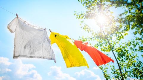 Fleckentfernung mit dem Bleichmittel Sonne: Wäsche hängt auf einer Wäscheleine in der Sonne
