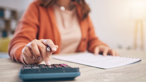 Frau mit Block und Taschenrechner