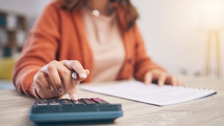 Frau mit Block und Taschenrechner
