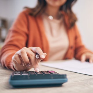 Frau mit Block und Taschenrechner