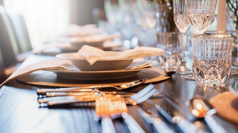 Mit Silberbesteck festlich gedeckter Tisch