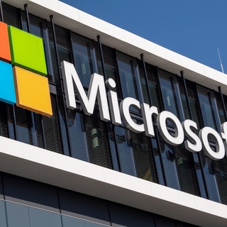 Das Microsoft Logo hängt an der Fassade eines Bürogebäudes