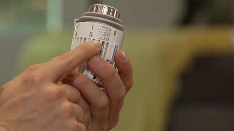 Ein Thermostat wird in einer Hand gehalten, es zeigt die Stufe 5. Wie kann umweltfreundlich geheizt werden?
