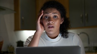 Eine Frau sitzt verzweifelt vor ihrem Computer. Kriminelle tarnen sich bei Amazon oder Ebay als seriöser Shop und kommen so an Kundendaten. Ihre Opfer stehen plötzlich selbst unter Betrugsverdacht.