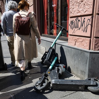 Umgekippte E-Scooter liegen auf dem Geweg. Wer haftet bei Unfällen durch rumliegnde E-Roller?