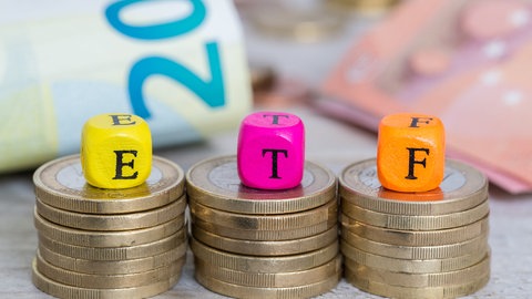 Drei Stapel Münzen, auf denen jeweils Würfel mit den Buchstaben E,T,F liegen