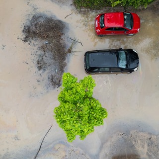 Autos stehen auf einem überschwemmten Parkplatz (Luftaufnahme mit einer Drohne). In der Nacht hatte ein Unwetter mit massiven Niederschlägen für hunderte Feuerwehreinsätze und lokale Überschwemmungen gesorgt.