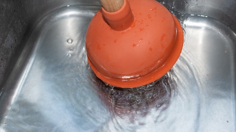 Abfluss wird mit Saugstampfer bearbeitet