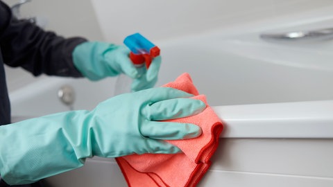 Badewanne wird mit Badreiniger geputzt