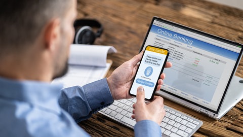 Mann macht beim Online-Banking Zwei-Faktor-Authentifizierung