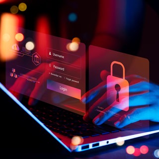 Mann tippt auf dem Laptop