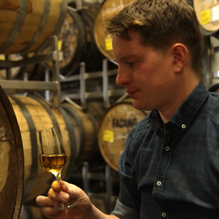 Jonas Klöckner steht mit kleinem Probierglas zwischen Fässern in der "Birkenhof"-Brennerei. Jedes Whisky-Fass hat seine eigene Geschichte.