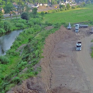 Eine 100 m lange und 10 m hohe Halde aus Schutt nach dem Ahr-Hochwasser wird von Lkw abgetragen