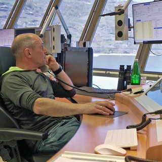 Mann arbeitet konzentriert und schaut auf Bildschirme in der Revierzentrale Oberwesel