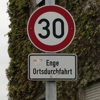 Ortsschild vor einer Hauswand