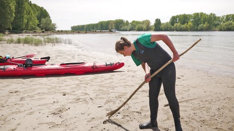 Mitglied vom Kanuclub Oppenheim schaut sich den Sandstrand genauer an