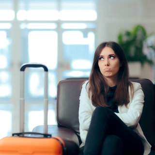 Frau sitzt unglücklich in der Hotellobby