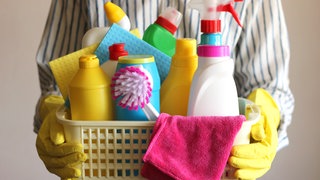 Mann hält Korb mit Putzutensilien