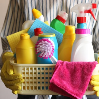 Mann hält Korb mit Putzutensilien