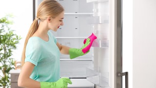 Frau reinigt Kühlschrank