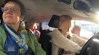 Fahrschülerin mit Fahrlererin und Prüferin in einer Simulationsprüfung