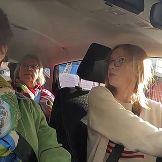 Fahrschülerin mit Fahrlererin und Prüferin in einer Simulationsprüfung