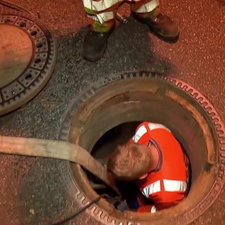 Bauarbeiter steigt in Kanalisation