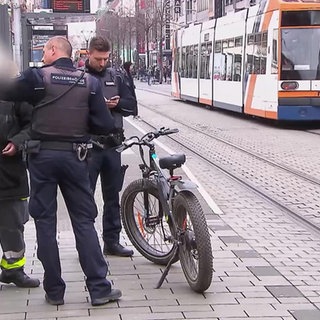 Peter Schröder und Sascha Schmidt sprechen mit einem Fahrradfahrer in der Mannheimer Innenstadt