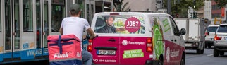 Ein Flink Kurier auf dem Fahrrad und ein Fahrzeug von Flaschenpost fahren auf einer Straße | Darauf solltet ihr bei Lieferdiensten für Lebensmittel achten