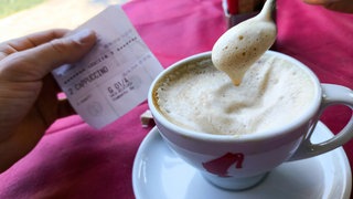 Eine Tasse Kaffee mit Kassenzettel | Darum könnte Kaffee bald teurer werden
