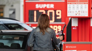 Eine Frau tankt ihre Auto an einer Tankstelle. | Schwankende Benzinpreise: Tankstellenpächter kritisieren die Mineralölkonzerne