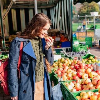 Frau kauft Äpfel auf dem Markt
