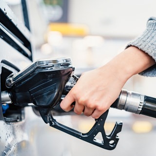 Eine Frau betankt ihr Auto: Es gibt Tipps, wo man wann am günstigsten Tanken kann.