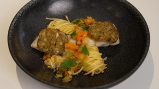 Kabeljau mit Kastanienkruste, cremigem Gemüse und Nudeln.